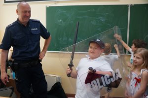 policjant z dziećmi w sprzęcie policyjnym