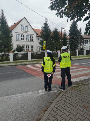 policjanci stoją w rejonie przejścia dla pieszych przy szkole