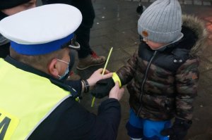 policjant wręczaq dziecku odblask
